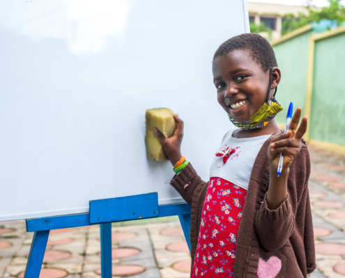 A closeup shot of a black male child erasing a whiteboard - education concept