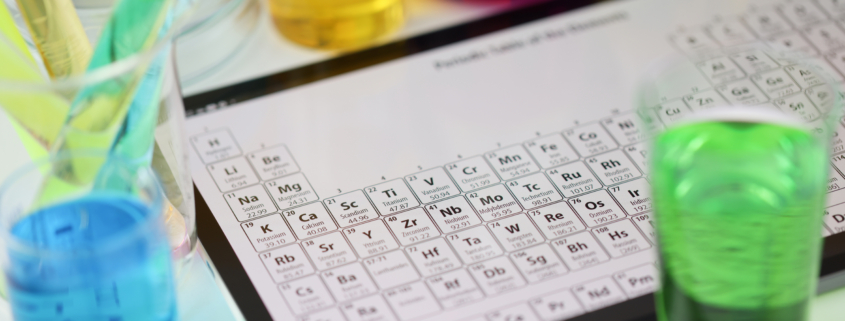 Digital tablet with periodic system of elements lying on table in laboratory closeup. Checking water quality concept