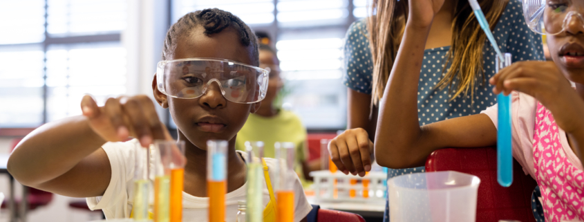 Diverse schoolgirls with chemistry items and liquids in elementary school class. School, learning, childhood, science, chemistry and education, unaltered.