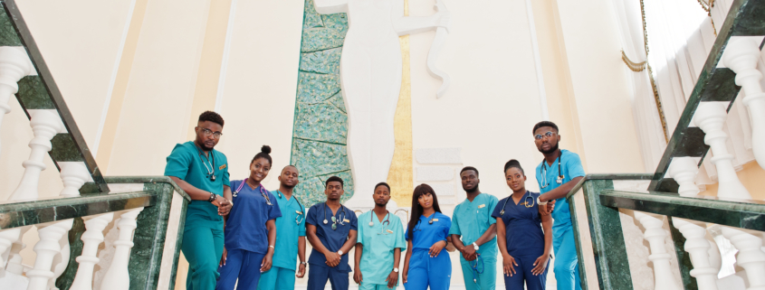 Group of african medical students in college standing on stairs.