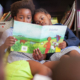 image of two children with a book reading