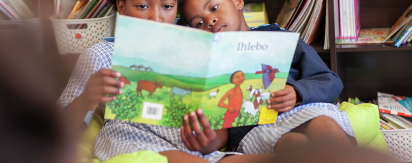 image of two children with a book reading