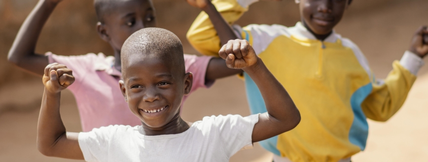 Excited African children with their hands up in the air