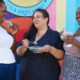 three moms together eating and laughing together standing outdoors