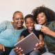 Portrait of African grandmother, mother and son taking a selfie with digital tablet at home. Technology and lifestyle concept.