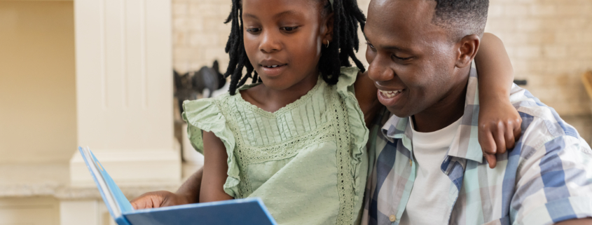 Reading storybook together, African father and child sharing smiles at home. Family, bonding, parenting, storytelling, togetherness, happiness