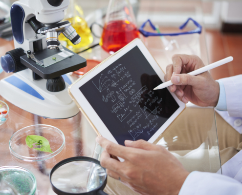 Scientist drawing chemical formulas and making calculations on tablet computer