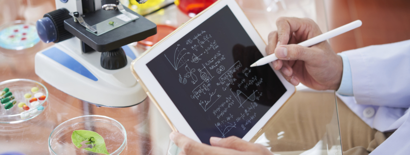 Scientist drawing chemical formulas and making calculations on tablet computer