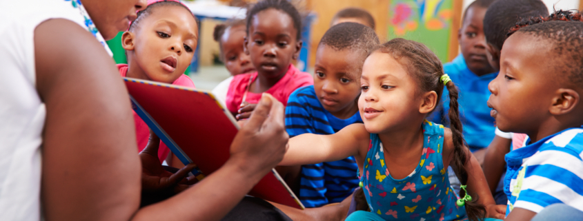Teacher reading a book with a class of preschool children