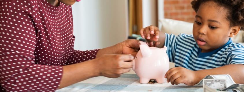 A woman and child saving money in a piggy bank. Coins and bills on the table. Teaching financial responsibility and saving habits. Family financial education. African family at home.