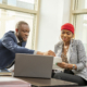 A young black businessman and woman going through some paperwork together for funding support