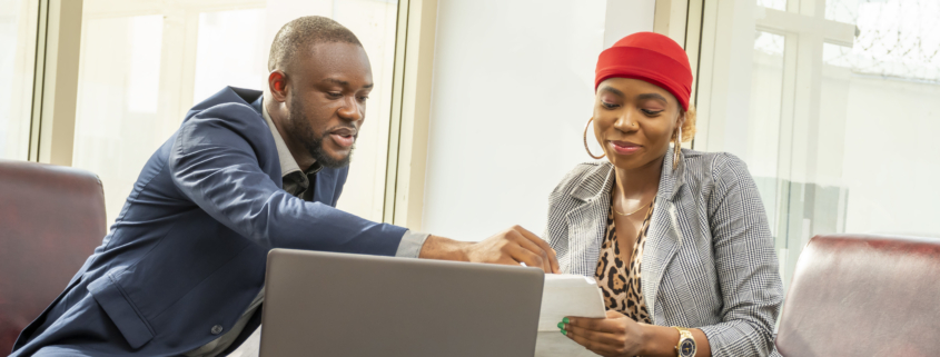 A young black businessman and woman going through some paperwork together for funding support