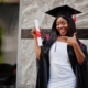 Young female african student with diploma poses outdoors. She got a bursary to attend university