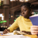 Young teenagers reading literary texts at the library as part of their curriculum, preparing for literature class lesson and enhancing their academic focus. Girls read the mandatory books titles.